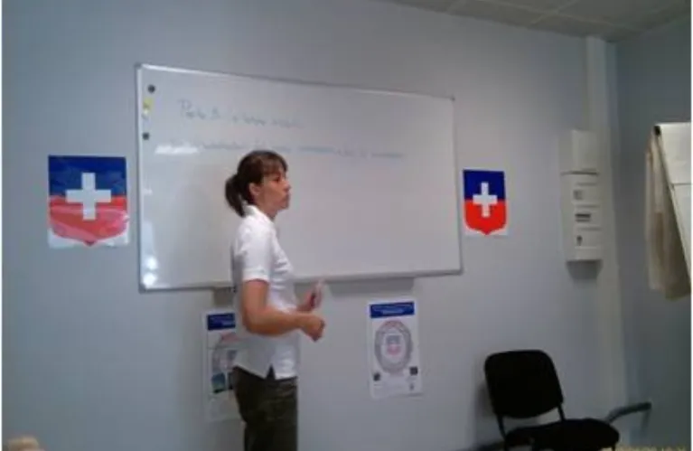 Une formatrice devant un tableau blanc, dans une salle aux couleurs de la Croix Blanche.