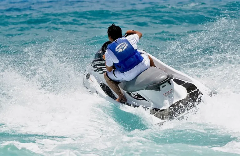 Un pilote en gilet de sauvetage conduit un bateau à moteur dans les vagues.