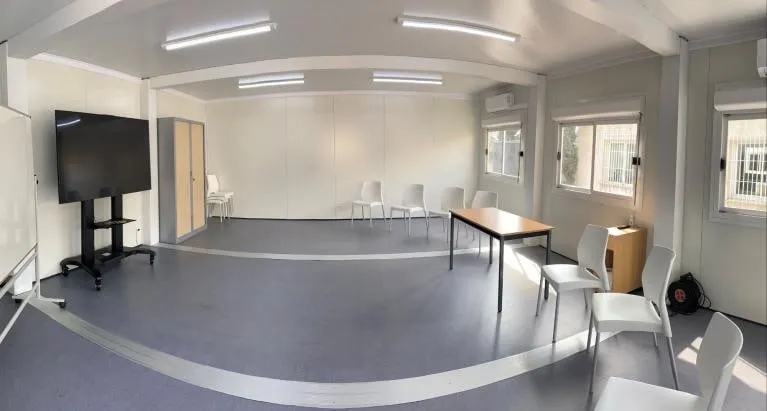 Salle En Vau, tables et écran au fond.
