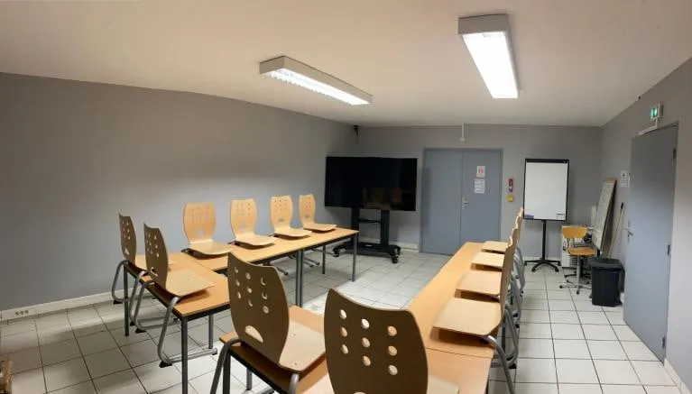 Salle Frioul, tables face à un grand écran.