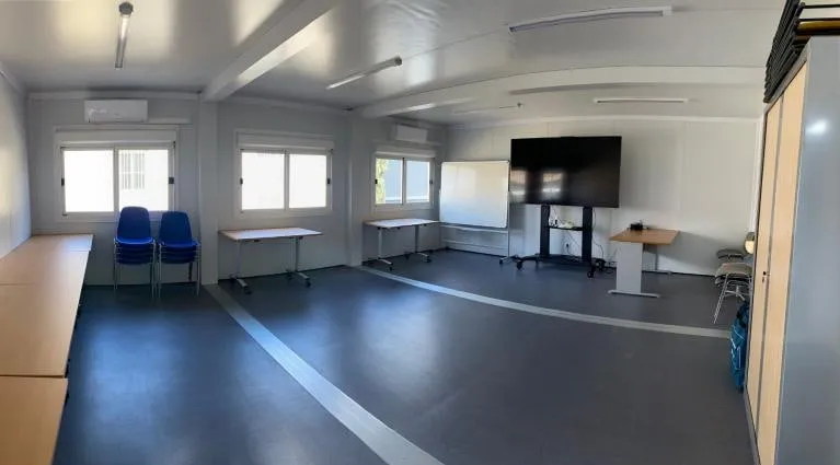 Salle Pomègues, salle lumineuse avec un écran.